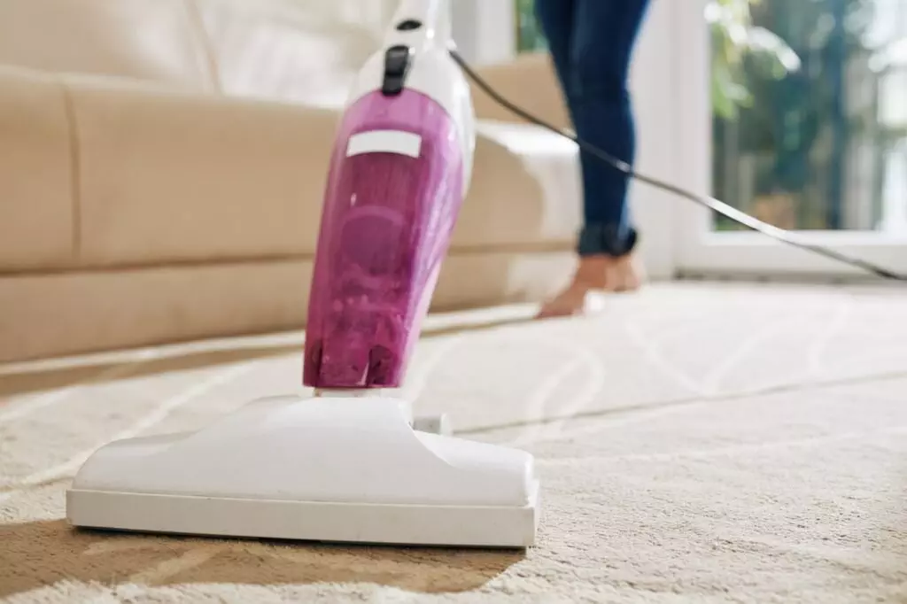 Woman vacuum cleaning carpet