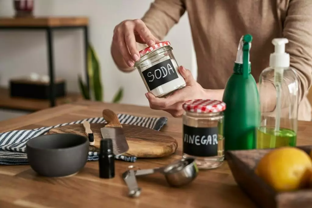 Unrecognizable person making cleaning product from ecological ingredients